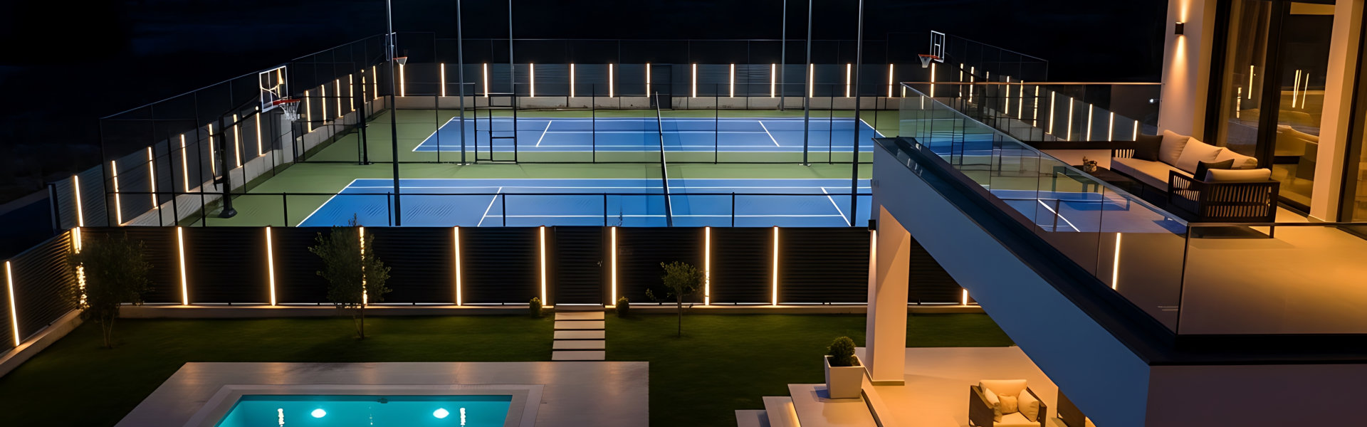 Illuminated modern mansion with a backyard pool and private padel court, showcasing a luxurious lifestyle at twilight